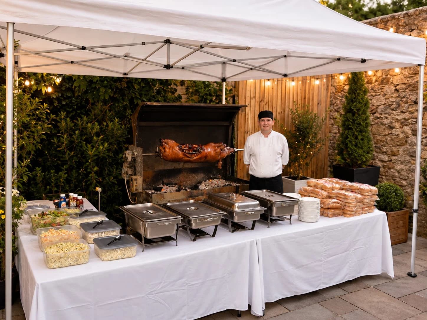 Gazebo, hog roaster, chafing dishes and dressed serving table set up in a walled courtyard
