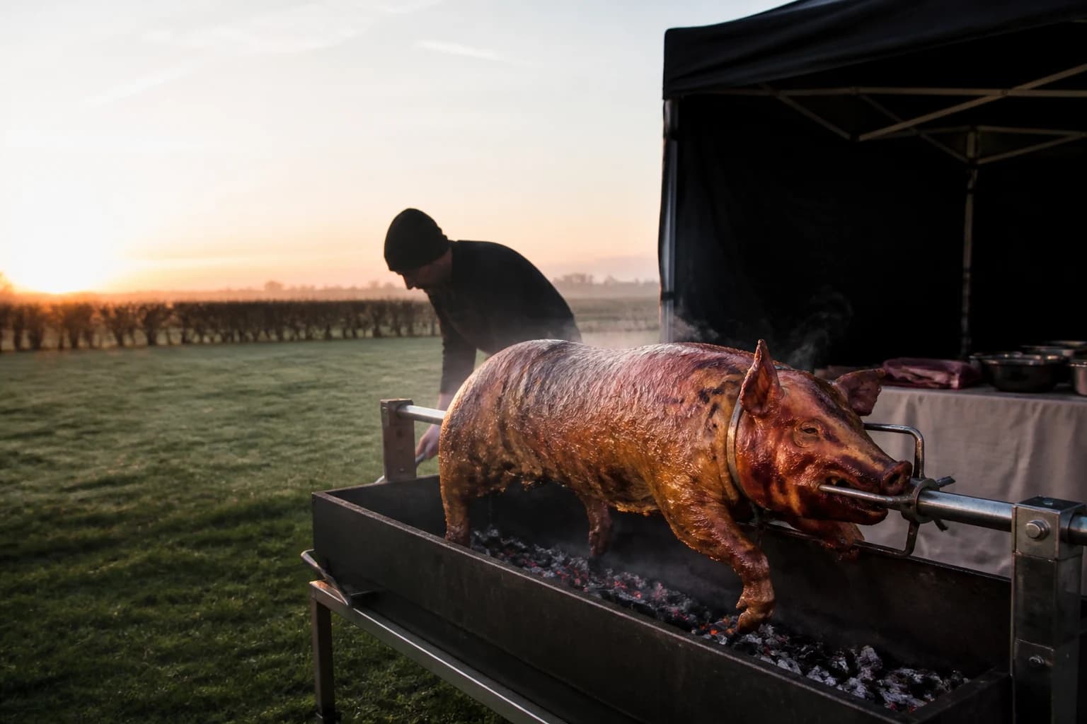 Whole hog turning on the spit, steam rising