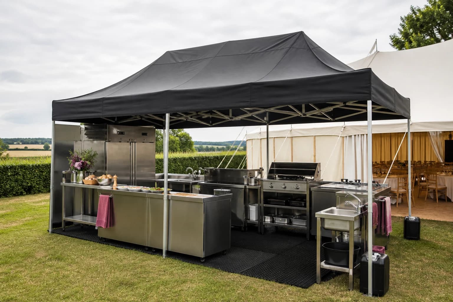 Outdoor kitchen and gazebo set up in a Cambridgeshire field before service