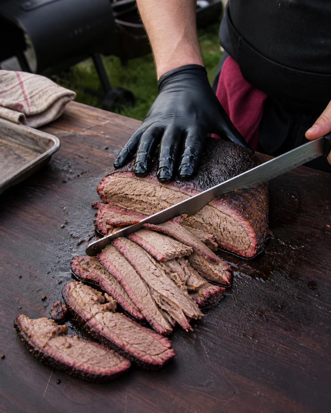 Smoked beef brisket being sliced, showing the smoke ring